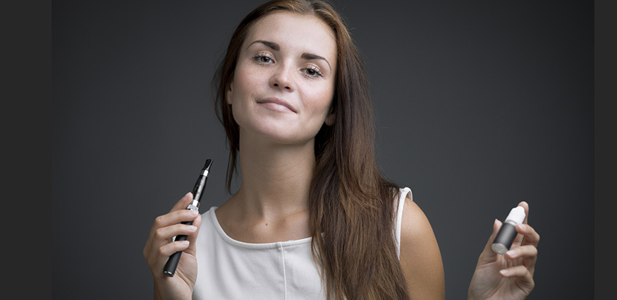 Woman using a nicotine vape pen. What is Synthetic Nicotine?